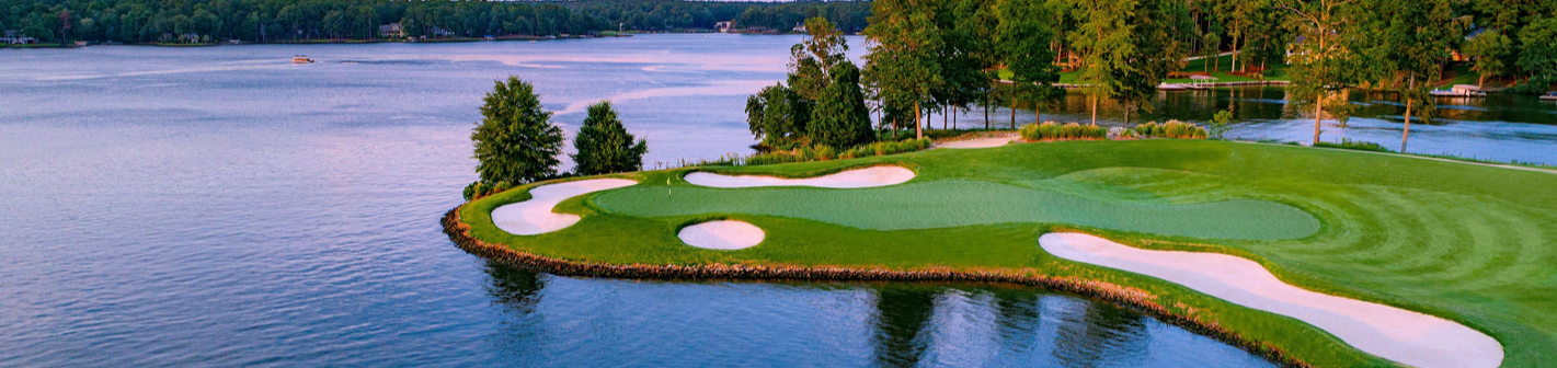 Golf course with a green surrounded by water and trees